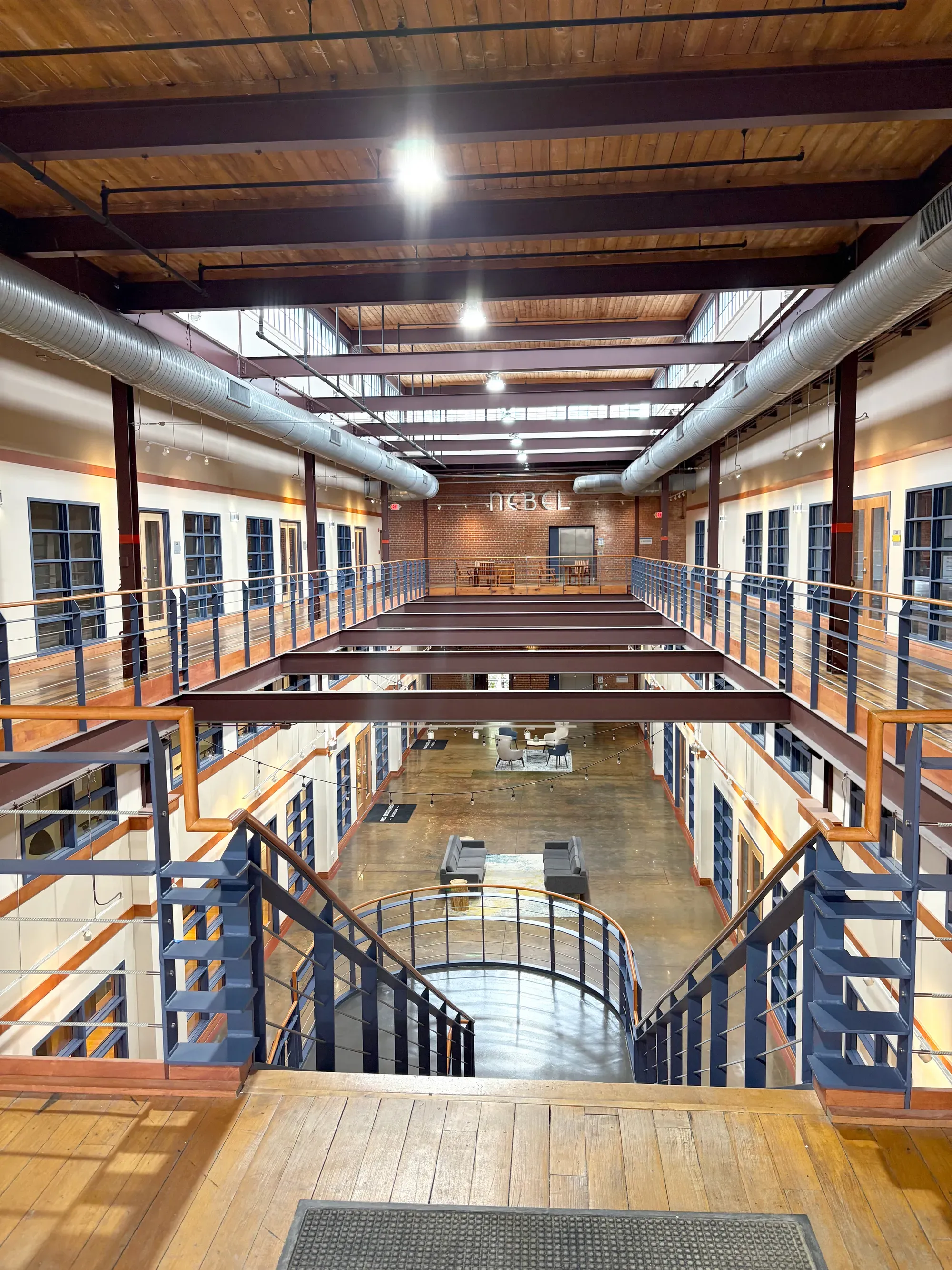 Image of industrial office space with wood floors, metal beams, exposed duct work